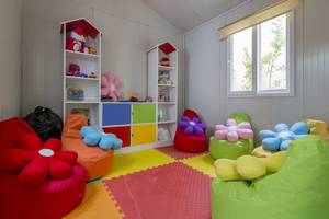 Kinderzimmer im Side Royal Palace Hotel & Spa mit bunten Kissen und Spielzeugregalen.