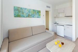 Wohnbereich des HSM Club Torre Blanca mit Sofa, Couchtisch und Küche