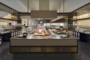 Im Restaurant H10 Las Palmeras bereitet ein Koch ein Buffet zu.
