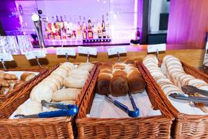 Frühstücksbuffet im XO Hotels Blue Tower mit verschiedenen Brotsorten und Croissants.