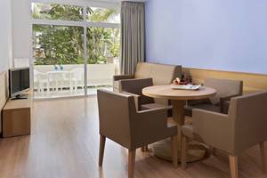 Wohnbereich des Tabaiba Princess Hotels mit Tisch, Stühlen und Fernseher.