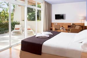 Ein modernes Hotelzimmer mit Doppelbett, Balkonzugang und Gartenblick im Tabaiba Princess Hotel.