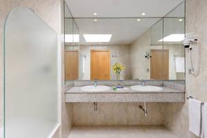 Badezimmer im Tabaiba Princess Hotel mit zwei Waschbecken, Spiegeln und Dusche.