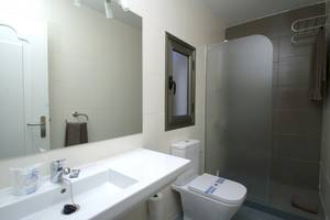 Badezimmer im Turbo Club mit Spiegel, Waschbecken, Toilette und Duschkabine.