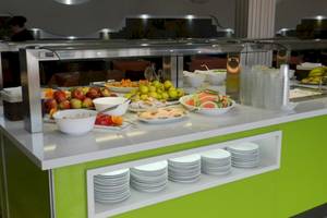 Buffet-Tisch im Turbo Club Hotel mit verschiedenen Obstsalaten, Desserts und Getränken.