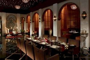 Innenbereich des Shangri-La Barr Al Jissah Resorts & Spa mit gepolsterten Stühlen und einem langen Esstisch.