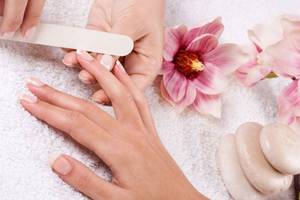 Nagelpflege im Hotel Steigenberger Aqua Magic mit rosa Blumen und Steinen im Hintergrund.