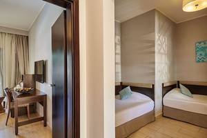 Doppelzimmer im Steigenberger Aqua Magic Hotel mit zwei Betten, Tisch und Fernseher.