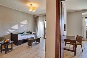 Zimmer im Steigenberger Aqua Magic Hotel mit einem Bett, einem Tisch, einem Stuhl und einer Lampe.