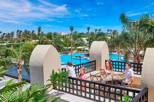 Familie genießt Ausblick auf den Pool vom Hotelbalkon aus