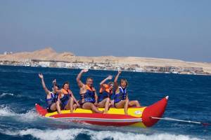 Gruppe auf rotem und gelbem Schlauchboot mit Stegenberger Aqua Magic im Hintergrund.