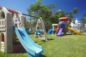 Kinderspielplatz im Atlantis Beach Hotel auf Kreta mit Rutschen und Schaukeln.