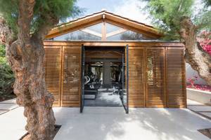 Außenansicht des Fitness Centers des Cretan Malia Park Hotels mit hölzernen Fenstern und Türen