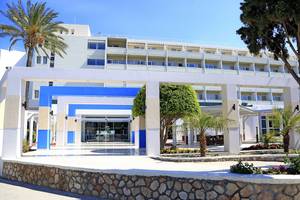 Vorderansicht des Blue Bay Beach Resorts mit Eingang, Säulen und Palmen