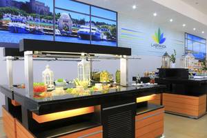 Buffetbereich im Blue Bay Beach Resort mit vielen Lebensmitteln und einer großen Fensterwand.