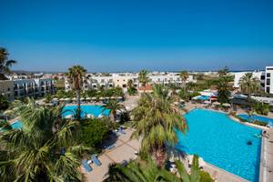 Hotelanlage mit Pool und Palmen von oben gesehen.