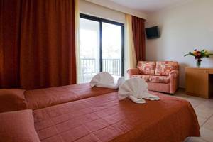 Hotelzimmer mit Balkon und Doppelbett im Tigaki Beach Hotel.