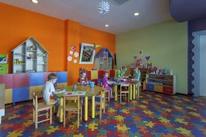 Kinderzimmer im Alba Queen Hotel mit bunten Wänden und Puzzleboden.