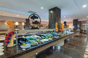 Buffet-Tisch im Alba Queen Hotel mit verschiedenen Gerichten und Dekorationen.