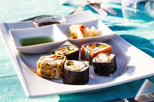 Teller mit verschiedenen Sushi-Rollen und Soße, serviert im Hotel Alba Queen.