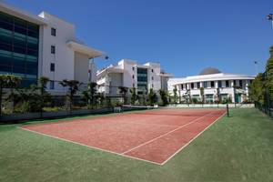 Tennisplatz vor dem Alba Queen Hotel, Gebäude im Hintergrund, sonniger Tag