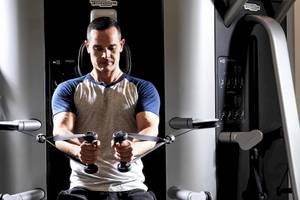 Mann im Fitnessstudio, der an einem Kabelzuggerät trainiert