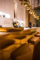 Empfangsbereich des Portugal Boutique Hotels mit Champagnerflasche, Gläsern und goldenen Pendelleuchten.