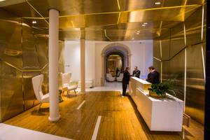 Empfangsbereich des Portugal Boutique Hotels mit goldenen Wänden und Holzboden.