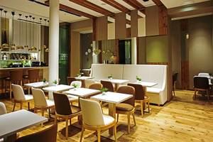 Innenbereich des Portugal Boutique Hotels mit weißen Tischen, Stühlen und Holzboden.