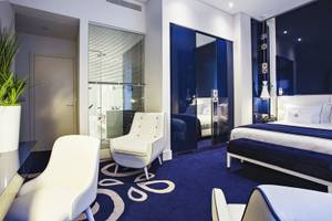 Portugal Boutique Hotel Schlafzimmer mit blauem Teppich und weißen Möbeln.