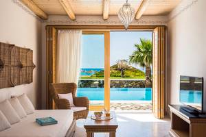Wohnzimmer des Mitsis Blue Domes Resorts & Spa mit Blick auf den Pool und die Insel.