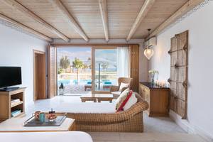 Wohnzimmer des Mitsis Blue Domes Resort & Spa mit Blick auf den Pool und Meer.