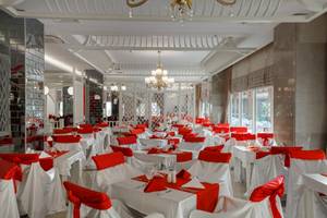 Innenbereich des Well Palace Side Hotels mit vielen weiß und rot gedeckten Tischen.