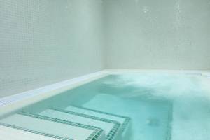 Innenansicht des Poolbereichs im Iberostar Selection Playa de Palma Hotel mit weißen Kacheln und Wasser