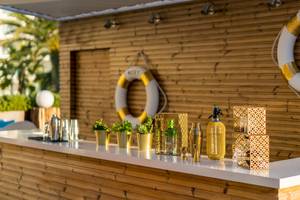 Barbereich im Iberostar Selection Playa de Palma Hotel mit holzverkleideten Wänden, goldenen Dekorationen und einer Flasche Moet.