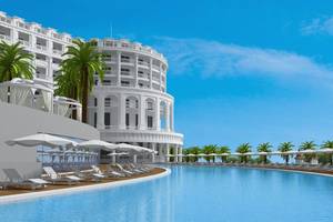 Aussenansicht des Defne Defnem Hotels mit Swimmingpool, Liegestühlen und Sonnenschirmen.