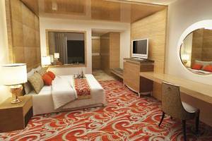 Hotelzimmer von Defne Defnem mit großem Bett, zwei Nachttischen, Schreibtisch, Stuhl, Spiegel und Fernseher.