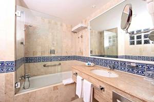 Badezimmer mit Badewanne, Spiegel und Handtüchern im Bahia Principe Grand Tulum