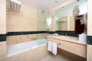Ein Badezimmer mit einer Badewanne, einem Spiegel und einem Waschbecken.