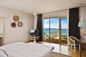 Zimmer im Dhigali Maldives Hotel mit Aussicht auf das Meer und eine Terrasse.