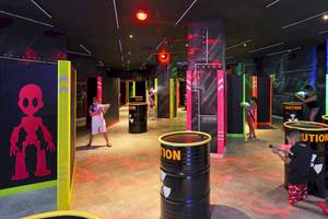 Kinder spielen Laser Tag in einem farbenfrohen Spielbereich des Sol Principe Hotels.