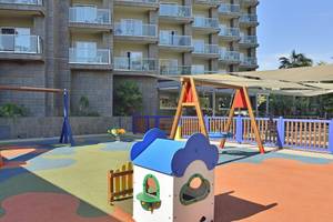 Kinderspielplatz vor dem Sol Principe Hotel mit Rutsche, Schaukel und Sandkasten.