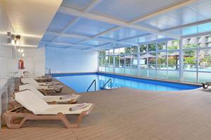 Innenpool im Sol Principe Hotel mit Liegestühlen und Sonnenschirmen.