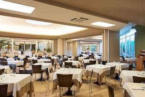 Innenansicht des Restaurants im VOI Alimini Resort mit geräumigen Tischen und Stühlen.