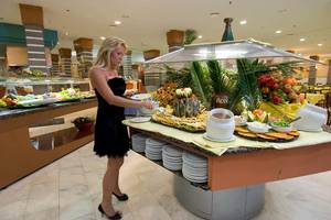 Eine Frau serviert Essen am Buffettisch im LIVVO Lago Taurito Hotel.