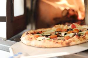 Eine Pizza mit Gemüse wird aus dem Ofen im Iberostar Selection Sabila Hotel genommen.