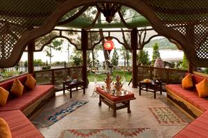 Gartenlounge im Rixos Premium Bodrum mit rotem Teppich, Sitzbank und orientalischen Lampen.