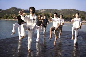 Gruppe von Menschen, die Yoga auf einem Steg am Wasser am Park Hotel Cala di Lepre machen.