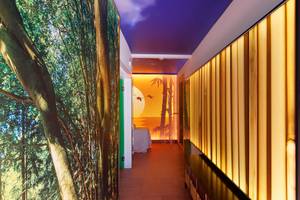 Korridor des Parque Tropical Hotels mit Wandgestaltung, die einen Wald und eine Sonnenuntergangsszene darstellt.