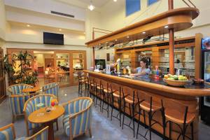 Die Bar des Okeanos Beach Hotel mit einer Theke und Sitzecken.